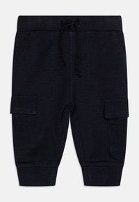Marineblå joggebukser laget av myk stoff, med ribbede mansjetter, elastisk snor i livet og to sidelommer.