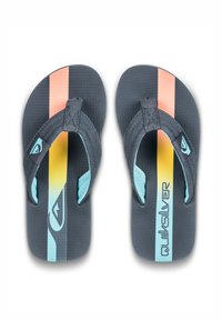 Svarte flip-flops med en tekstureret overflade, der har blå stropper og et multicolor design med orange og gule striber. Brandingen er synlig.