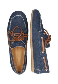 Båtshoes i denim med en fransad kantdesign, bruna läderremmar och tan gummisulor. Ovandelen är gjord av blå denimtyg.