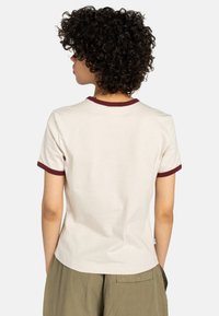 Korte mouwen, crew neck t-shirt in off-white katoen met bordeauxrode ribbelafwerking op de kraag en mouwen, effen achterkant.