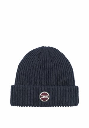 Bonnet en maille côtelée bleu foncé avec bord replié et écusson circulaire du logo de la marque Colmar au centre avant.