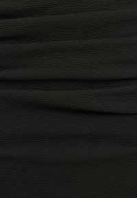 Tissu texturé noir présentant un motif subtil en forme d'ondes, avec une finition lisse et un aspect drapé, idéal pour diverses applications vestimentaires.