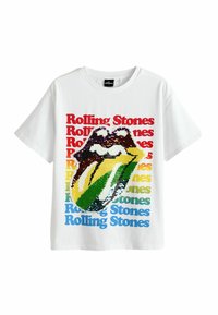 Valkoinen puuvillapaita, jossa on Rolling Stones -logo värikkäistä paljeteista. Teksti "Rolling Stones" näkyy punaisena, sinisenä, keltaisena ja vihreänä.