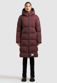 Bordeauxfarbene Pufferjacke mit Kapuze, mit einem durchgehenden Frontreißverschluss und einem knielangen Design. Schwarze Akzente an den Reißverschlüssen und ein Logo-Patch am Saum.