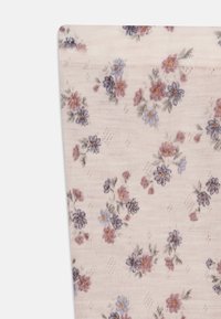 Meias de tornozelo florais em tecido suave e rosa claro com um padrão de flores roxas e amarelas. Material texturizado com um acabamento canelado fino ao longo do topo.