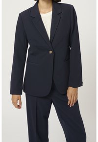 Granatowa marynarka wykonana z gładkiego materiału, z zapięciem na jeden guzik, klapami i dwoma przednimi kieszeniami, w połączeniu z pasującymi spodniami.