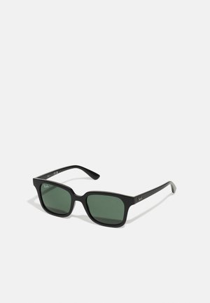 Lunettes de soleil rectangulaires noires avec des verres verts. Fini mat et design de branches classique. Logo Ray-Ban sur les branches.