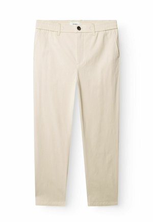 Beżowe casualowe spodnie z elastycznym paskiem, szlufkami na pasek, przednim guzikiem, zamkiem błyskawicznym i bocznymi kieszeniami, rozłożone płasko na białym tle.