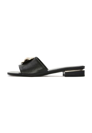 Sandalo scivolato in pelle nera con suola piatta, punta aperta e un accento metallico decorativo sulla fascia superiore. Design minimalista con tacco basso.