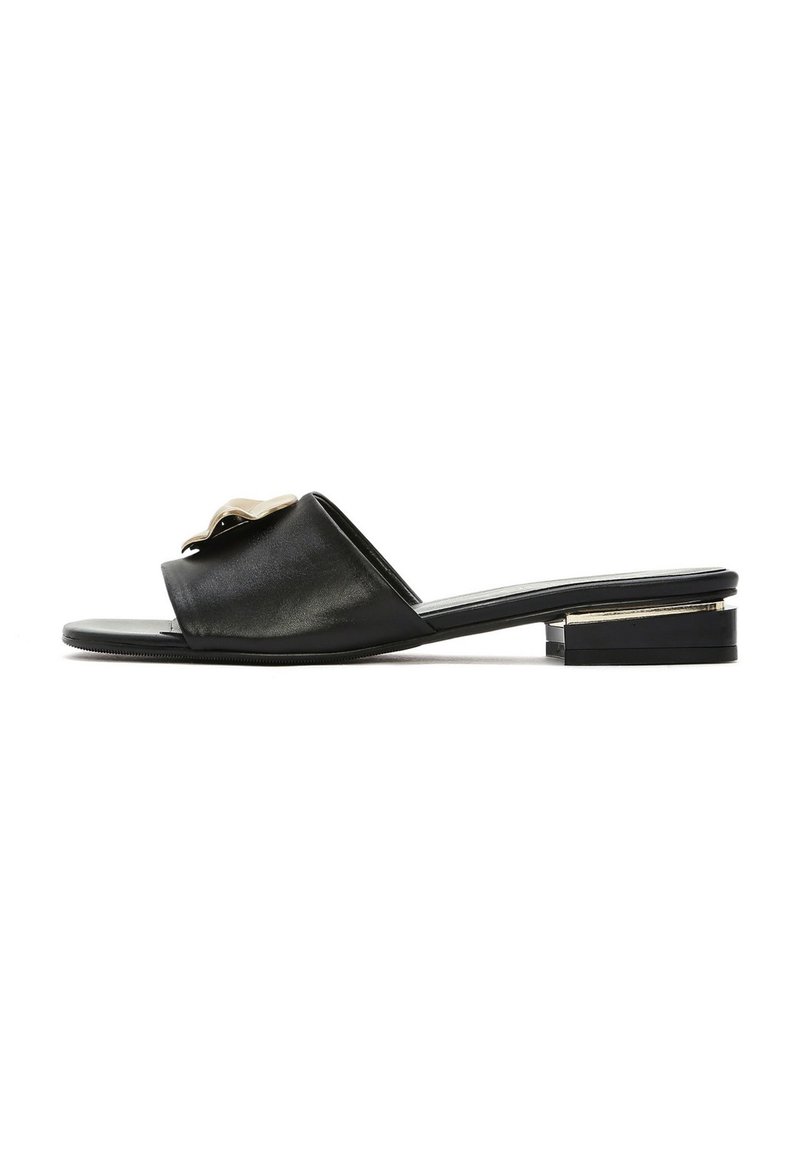 Zwarte leren slider-sandaal met een platte zool, open teen en een decoratieve metallic accent op de bovenband. Minimalistisch ontwerp met een lage hak.