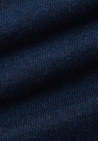 Granatowa dzianina o delikatnej strukturze, ukazująca zbliżenie na splatające się oczka oraz miękką, gładką powierzchnię.