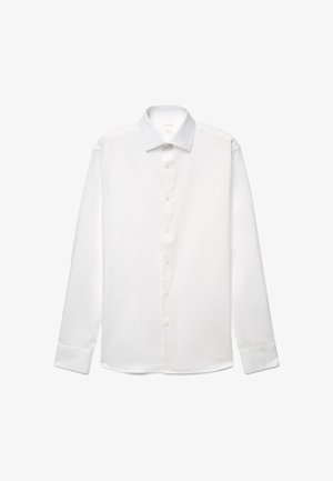 Chemise blanche à manches longues avec boutons, col pointu et poignets boutonnés, affichée à plat sur fond blanc.