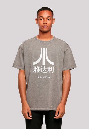 Grau übergroßes T-Shirt aus Baumwolle mit einem weißen grafischen Design und dem Text "BEIJING" sowie stilisierten Symbolen auf der Vorderseite.
