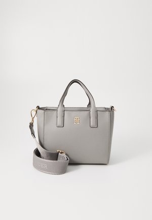 Graue Handtasche mit goldenen Beschlägen, zwei kurzen Griffen und einem abnehmbaren Schulterriemen. Strukturmaterial; mit einem eingeprägten Logo auf der Vorderseite.