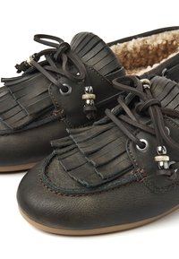 Schwarze Leder-Mokassins im Stil mit Fransenverzierungen, Schnürverschluss mit dekorativen Perlen und einem weichen, fellähnlichen Innenfutter.