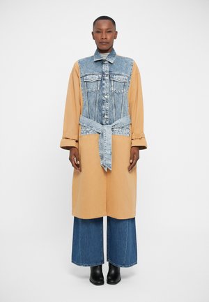 Denim ja beežist särgist koosnev kleit, millel on nööpidega esiosa, vöökoht ja pikad varrukad. Laiad laienevad denimipüksid ja mustad pahklauenõud.