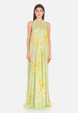 Abito lungo verde a pieghe con scollatura a halter. Presenta motivi floreali gialli, tessuto leggero e una silhouette fluttuante.