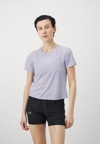 Šviesiai violetinė sportinė marškinėliai trumpomis rankovėmis ir apvaliu iškirpimu, derinami su juodais šortais, kurie turi tekstūruotą audinio dizainą.