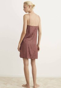 Vestido de satén burdeos tipo slip con tirantes finos, presenta un sutil patrón floral, diseño hasta la rodilla y una textura suave.