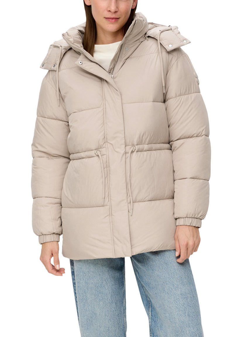 Puffermantel in hellbeige, mit durchgehendem Reißverschluss, abnehmbarer Kapuze, elastischen Bündchen und zwei vorderen Taschen mit Kordelzugtaille.