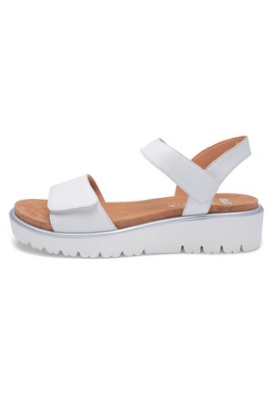 White platform sandal with two adjustable straps, tan cushioned footbed, and thick ridged sole for casual wear.