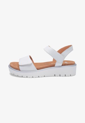 White platform sandal with two adjustable straps, tan cushioned footbed, and thick ridged sole for casual wear.