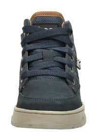 Donkerblauwe sneaker met dikke veters, beige zool, bruine gewatteerde kraag en een klein merketiket aan de zijkant.