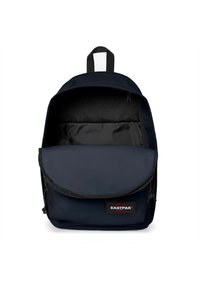 Mochila Eastpak azul marino con un gran compartimento principal, bolsillo frontal con solapa y acento de malla negra. Hecha de un tejido duradero con cierre de cremallera.