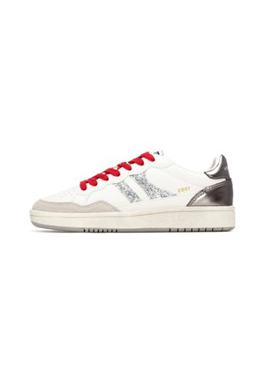 Zapatilla de cuero blanco con detalles grises, franjas plateadas brillantes, cordones rojos y talón metálico; suela de goma texturizada para mayor agarre.