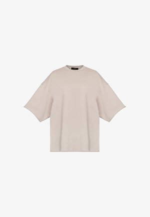 Beżowy oversize t-shirt z krótkim rękawem, opuszczonymi ramionami i okrągłym dekoltem, przedstawiony na białym tle.