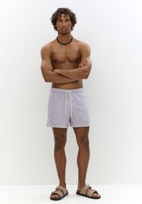 Férfi csíkos fürdőnadrág világos lila és fehér színben, elasztikus derékpánttal és zsinórral, oldalzsebekkel és laza szabással.