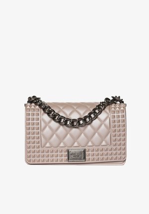 Sac à main beige matelassé avec bords cloutés, grande sangle chaîne noire et plaque métallique portant l'inscription "Marc Ellis New York".