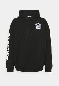 Sudadera negra de algodón, con un bolsillo canguro en la parte frontal, capucha con cordón y un estampado "WORLDWIDE" en una de las mangas.