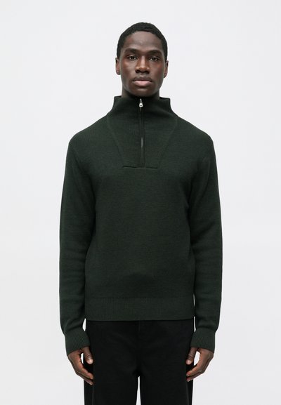 Suéter de cuello alto de color verde oscuro hecho de tela de punto texturizada, con cierre frontal con cremallera y puños y dobladillo acanalados.