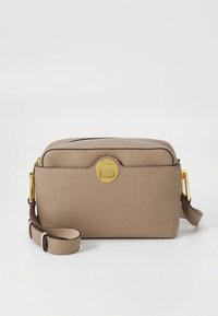 Geantă crossbody din piele bej cu finisaj texturat, accesorii aurii, partea superioară rotunjită și o curea reglabilă. Dispune de închidere cu cataramă frontală.