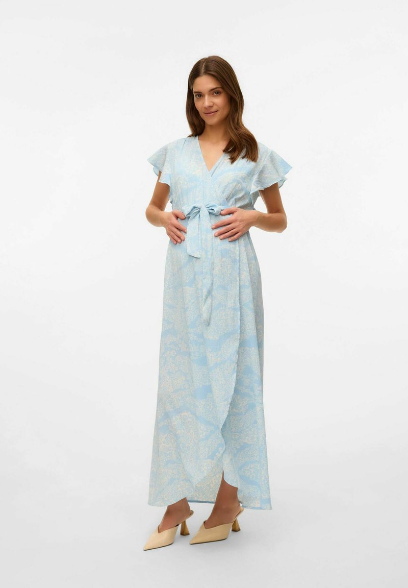 Svetlo modra obleka s cvetličnim vzorcem, kratkimi volančastimi rokavi, kravato v pasu in dolgotrajno silhueto. Oblečena z bež čevlji.