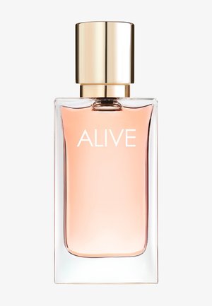 Klar rektangulær glassparfymeflaske med rosa væske og gullokk, merket "ALIVE" på forsiden.