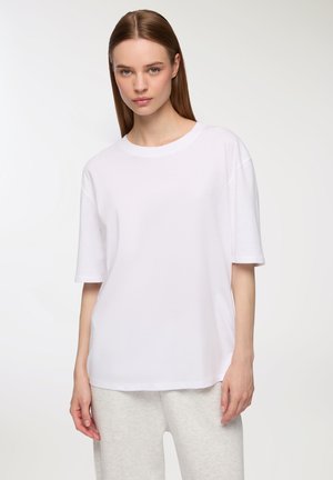 T-shirt bianco in cotone con una vestibilità morbida, maniche corte e scollatura rotonda. Texture liscia con un design semplice e classico.