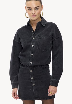Ensemble en denim noir comprenant une chemise et une jupe avec col, boutons sur le devant et embellissements subtils. Tissu texturé avec une taille cintrée.