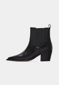 Μαύρο δερμάτινο μποτάκι αστραγάλου με μυτερή μύτη, ελαστικά πλαϊνά, θηλιά για τράβηγμα και τακούνι μπλοκ, σε λευκό φόντο.