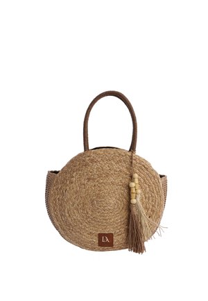Bolso redondo de paja tejida con asas marrón oscuro, borla beige con cuentas de madera y un pequeño parche de logo marrón en el centro inferior.