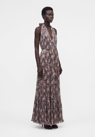 Γυναίκα με μακρύ αμάνικο φόρεμα με λουλούδια και halter neck, με εφαρμοστή μέση και βολάν στο τελείωμα, σε συνδυασμό με μαύρα ανοιχτά ψηλοτάκουνα.