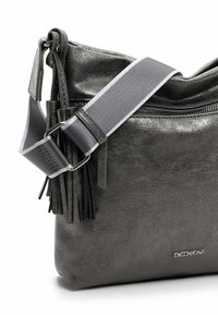 Gray faux leather crossbody bag with a zip closure, adjustable strap, and fringe detail on one side. Features branded hardware.