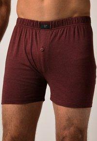Boxer in cotone bordeaux con cintura elastica e chiusura a bottone singolo. Tessuto liscio e design aderente.