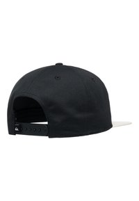 Svart caps med hvit skygge, laget av stoff, med snapback-lukking og seks ventilasjonsåpninger. Bakdelen er glatt med logodetalj.