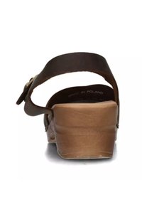 Sandalo in pelle marrone con una larga fascia e fibbia regolabile, caratterizzato da un tacco basso a blocco e una soletta texturizzata per il comfort.