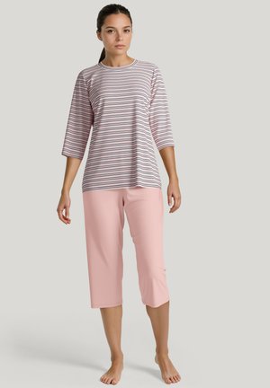 Gestreepte langemouwen top in wit, roze en marineblauw; gecombineerd met lichtroze cropped broeken. Zacht materiaal, ontspannen pasvorm en ronde halslijn.