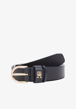 Zwarte leren riem met een goudkleurige afgeronde gesp en een klein gouden "TH" logo op de lus van de riem, opgerold op een witte achtergrond.