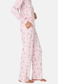 Rosa pyjamasett med en mjuk textur, prydd med ett mönster av djur och fjärilar. Byxorna har fickor och en justerbar midjeband.