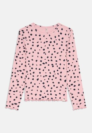 Pink long-sleeve ribbed shirt with irregular black polka dots and ruffled edges on sleeves and hem.